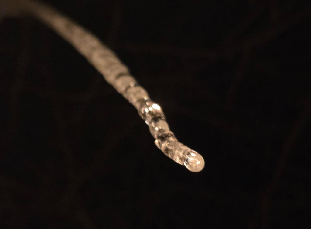 a long drip of icicle against a black background