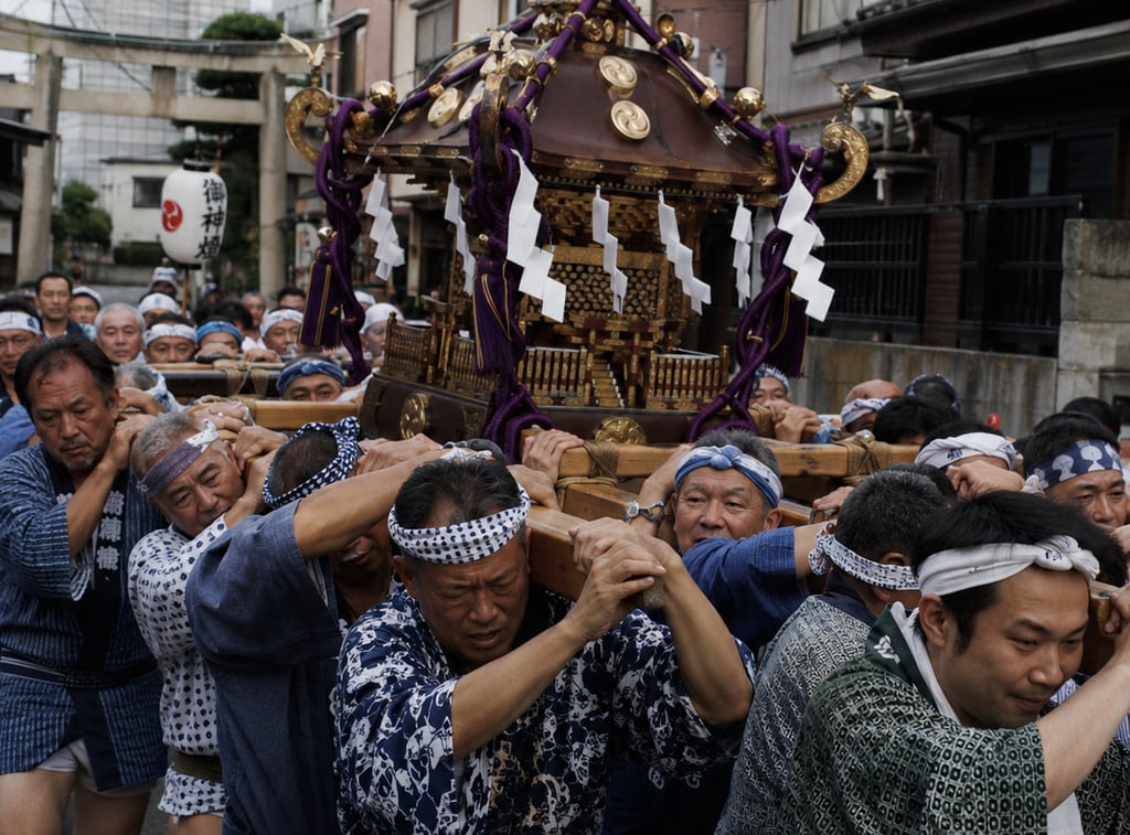 Participants carry a traditional Mikoshi portable shrine during a Japanese Shinto festival parade.