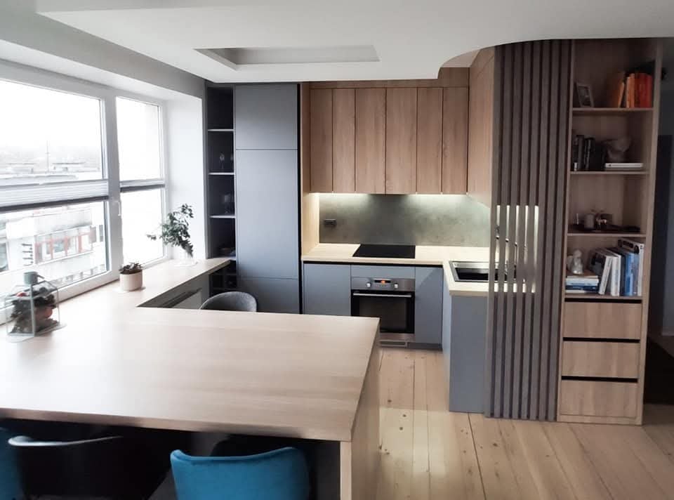 Natural oak ties the custom kitchen and hallway bookshelves together, creating a warm and se