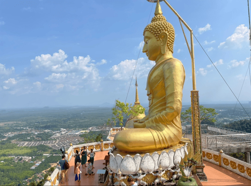 Riesige goldene Buddha-Statue am Tiger Cave Temple in Krabi, Thailand, mit Blick über das Tal.
