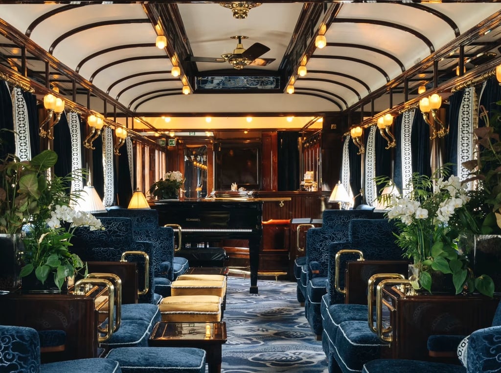 Art deco bar car inside the Venice Simplon-Orient-Express with plush blue velvet seating.
