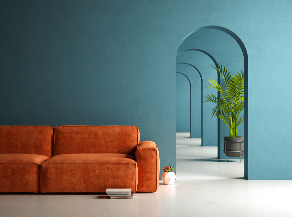 Modern living room with orange velvet sofa against a teal wall and arched hallway.