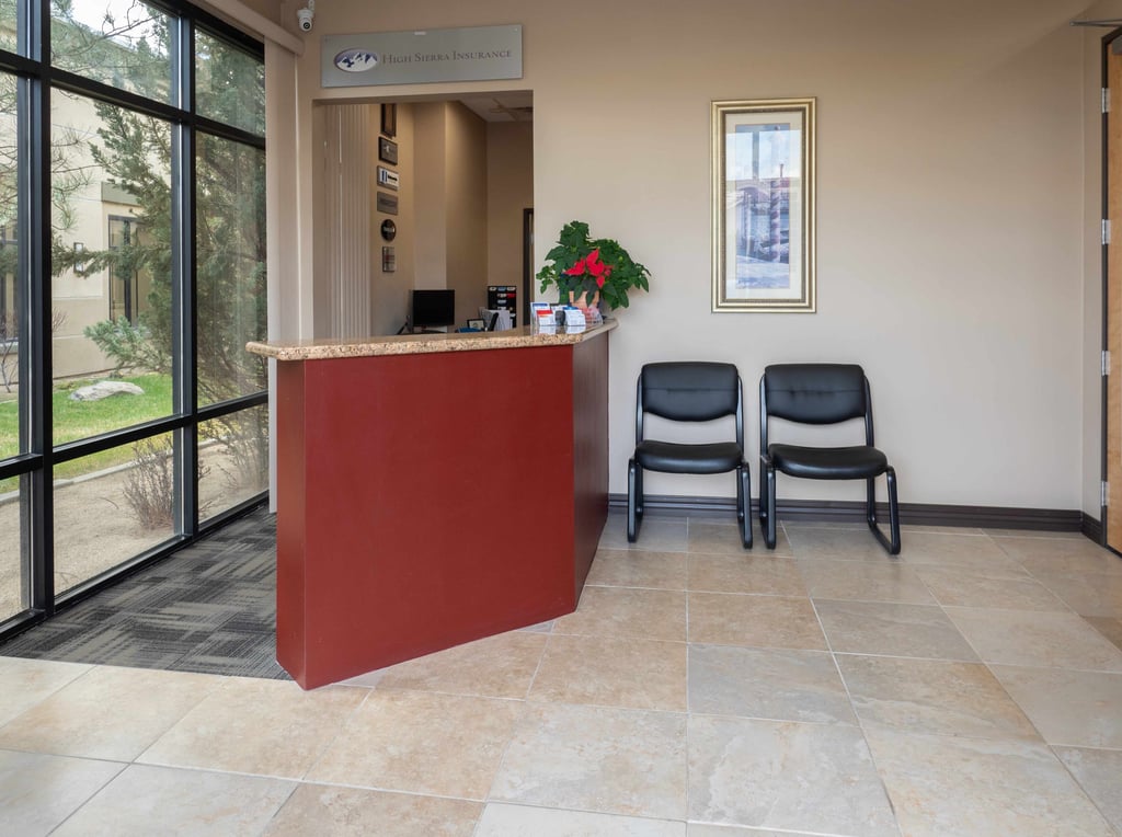a reception desk with two chairs and a desk
