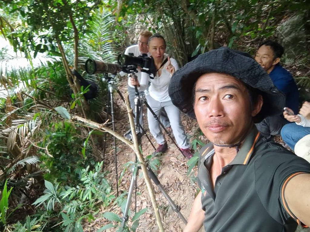 A local Da Nang guide leading professional photographers on a specialized wildlife photography tour.