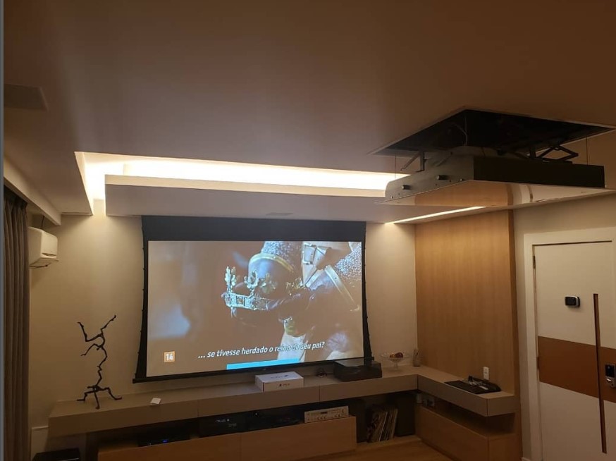 Projetor transmitindo imagem para tela eletrica em sala de estar