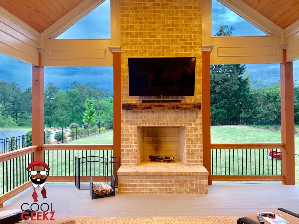 outdoor tv mounted over a brick fireplace