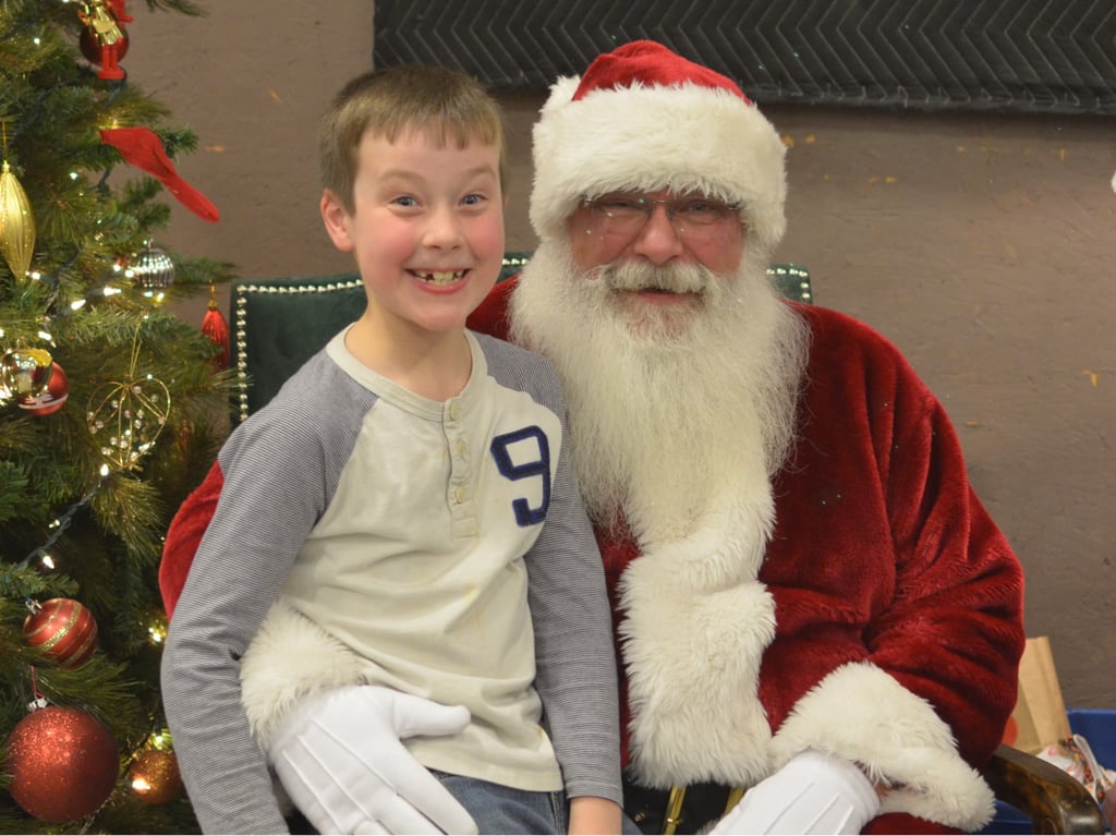 Santa Tom with smiling boy sitting on knee