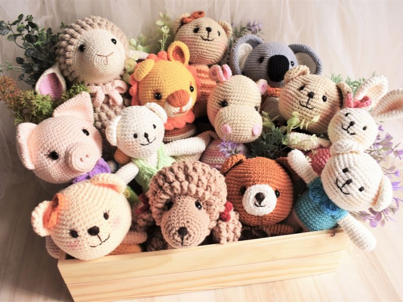 Colección de animales amigurumi tejidos a crochet hechos a mano en una caja de madera