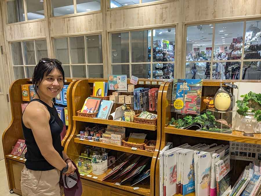 Traveler browsing Studio Ghibli souvenirs in Osaka, Japan.