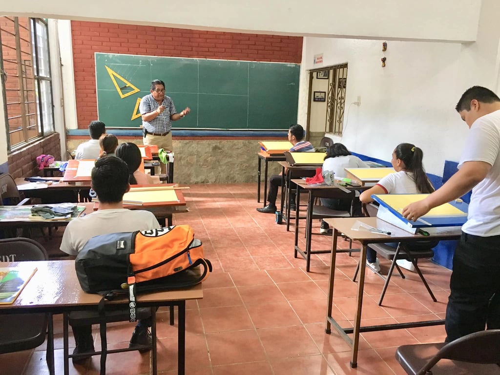 Alumnos tomando clase en el aula