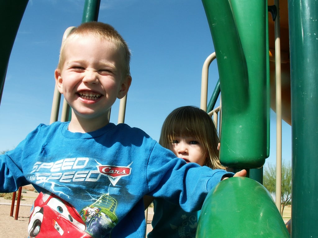 Boy sliding for sensory input on play structure during OT session