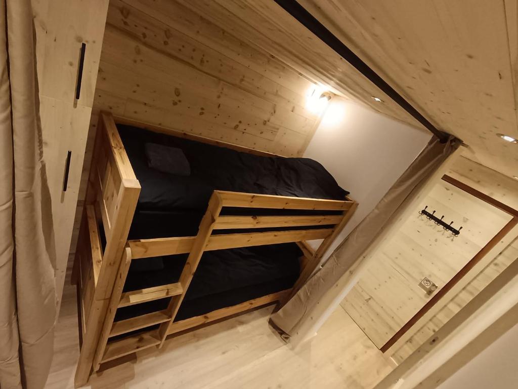 Bunk bed sleeping area in a cozy Val Thorens ski apartment with warm alpine wood interior.