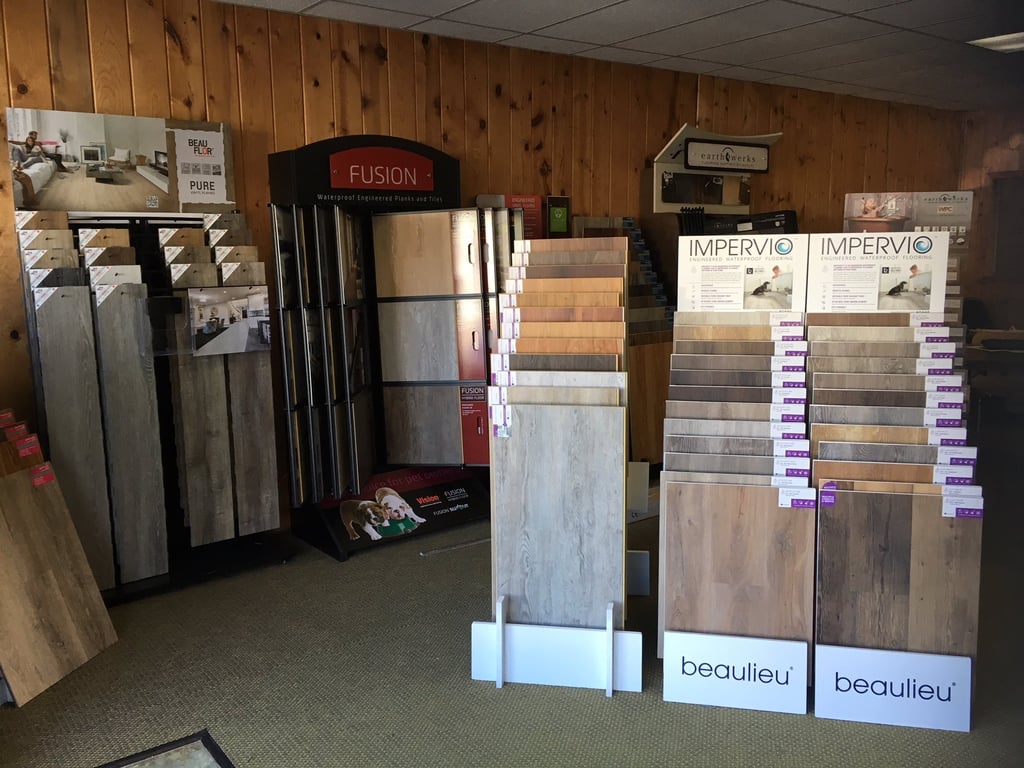 Flooring showroom displaying hardwood, laminate, tile, and vinyl flooring options.