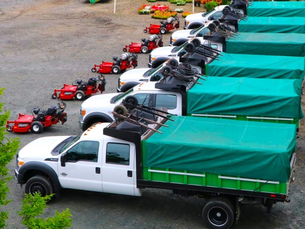 fleet of landscaping trucks with equipment
