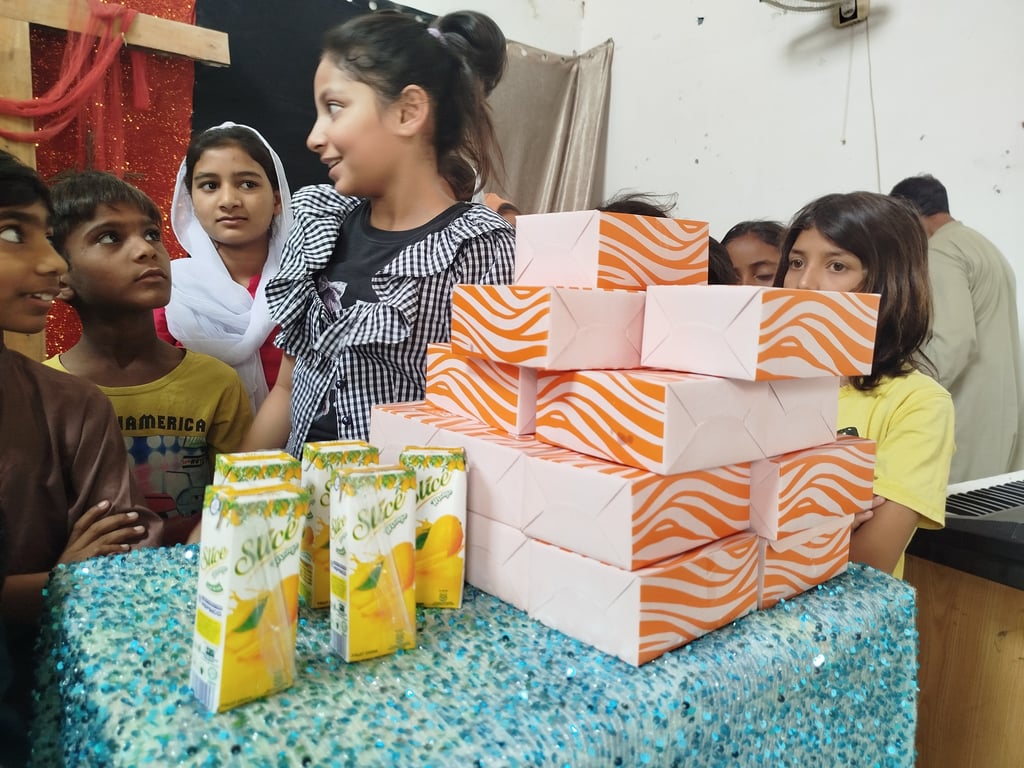 Abigail Amir Fazal distributing food and drinks to Sunday School children