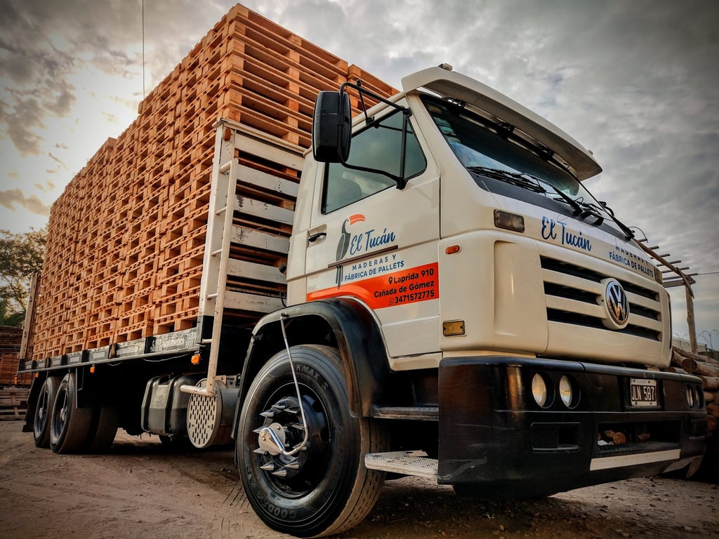 Camión cargado con pilas de pallets de madera nuevos para su transporte.