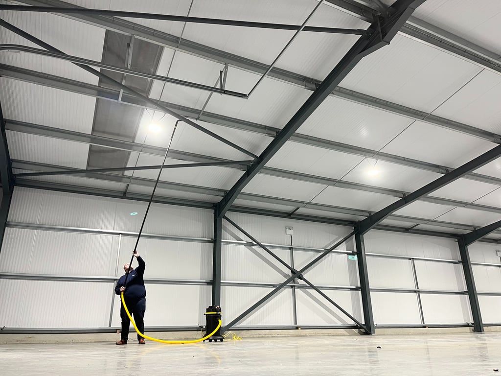 high commercial ceiling being vacuumed