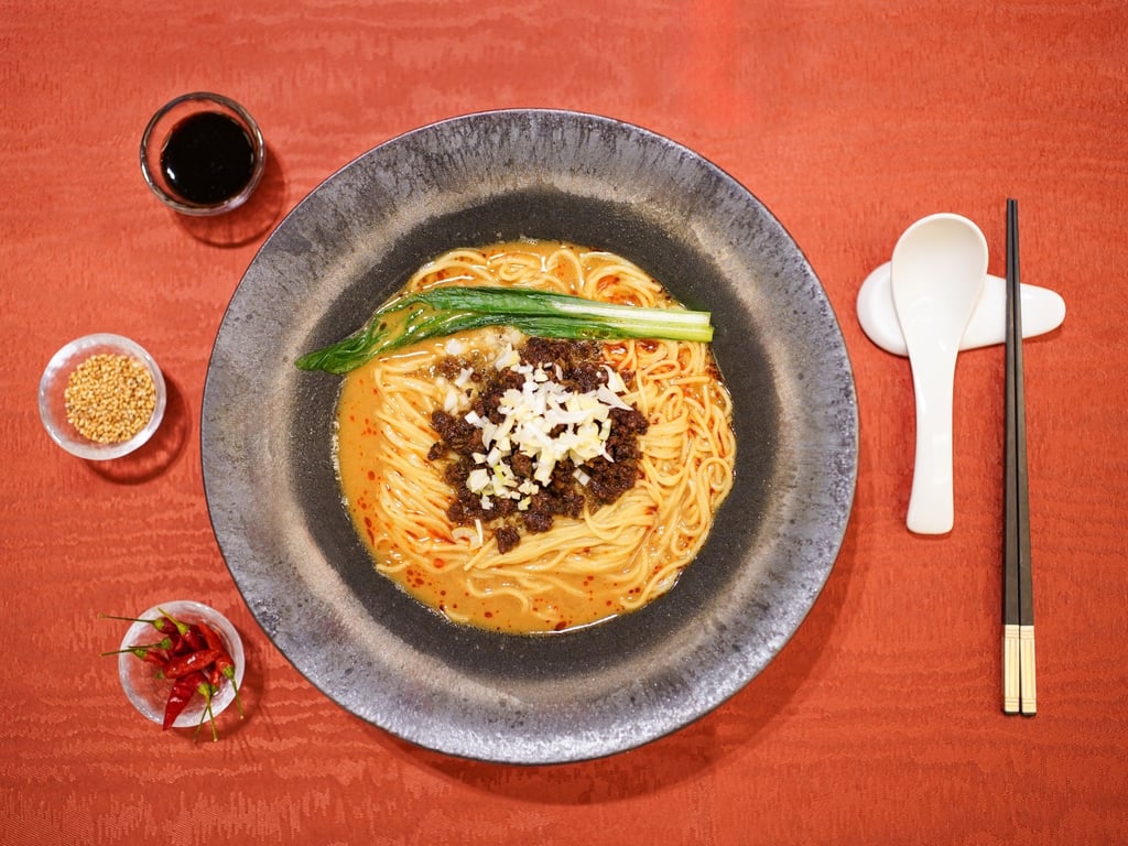 ホテル アゴーラ リージェンシー 大阪堺「龍鳳」の堺の味わい担々麺。金胡麻や鷹の爪を使い、具材やスープ、器、箸が並ぶ料理写真。