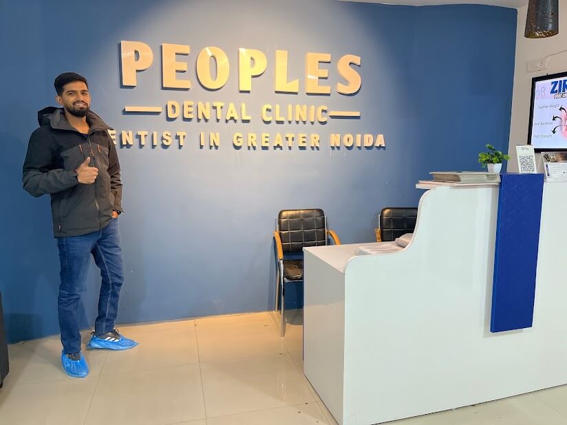A dental patient at Peoples Dental Clinic showing a Thumbs up and recommending the dentist in greater noida