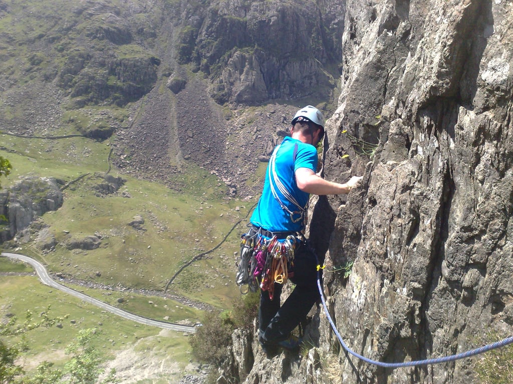 climber high on a rockface, traversing