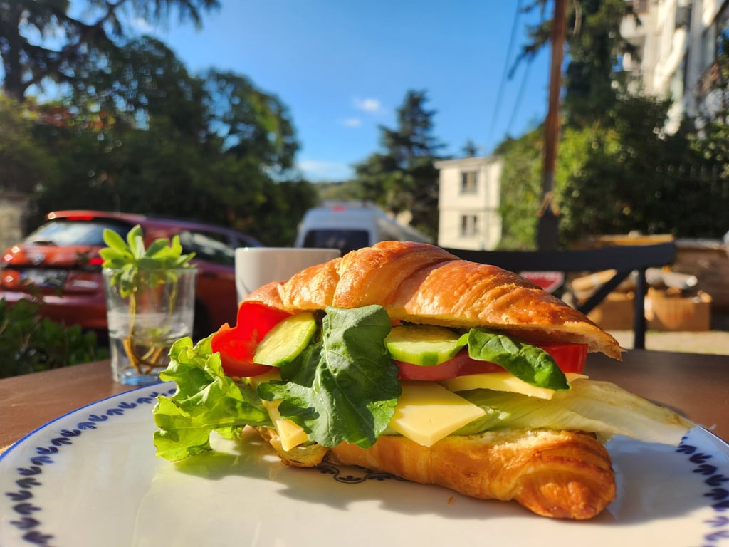 içinde salatalık, domates, yeşillik ve avokado buluanan kruvasan