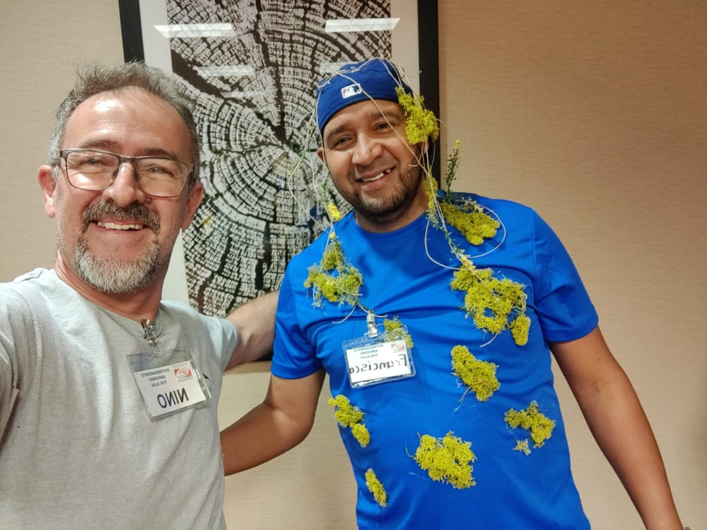 Two men posing for a photo with one wearing moss and vines as a decorative costume element.