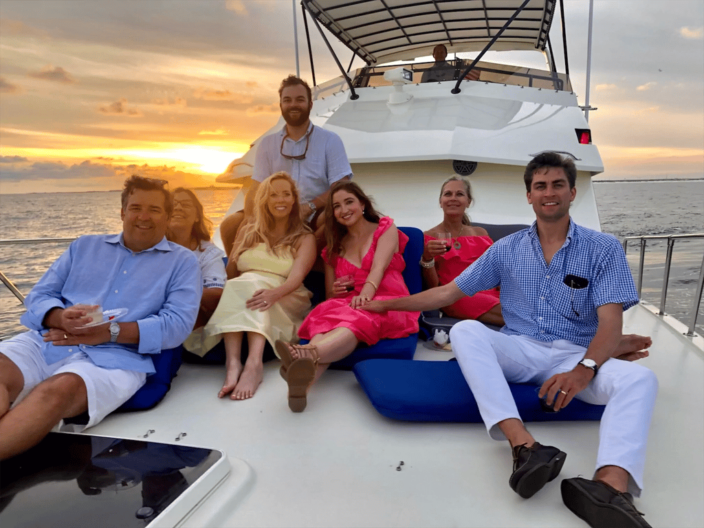 A group of friends enjoys a luxury sunset yacht cruise with drinks on the deck.