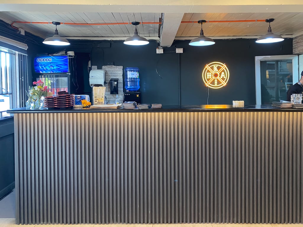 Diseño de barra de sushi listonada con iluminación técnica por Atípico Studio en Santiago.