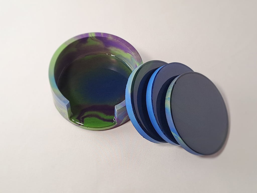 Handmade coasters in blue, purple, and green with a matching holder.