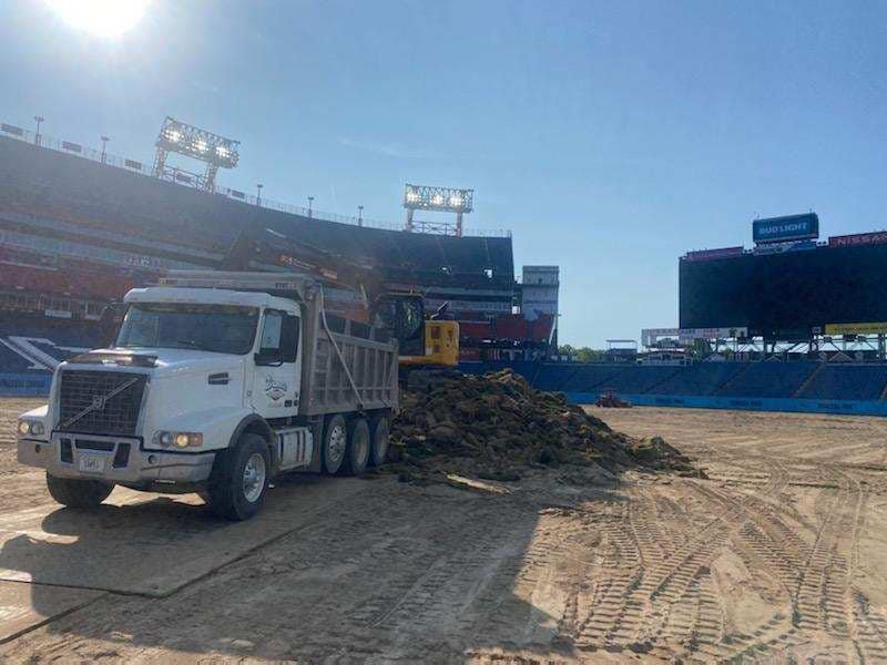 DumpTruck unloading soil to help level a playing field, material hauling