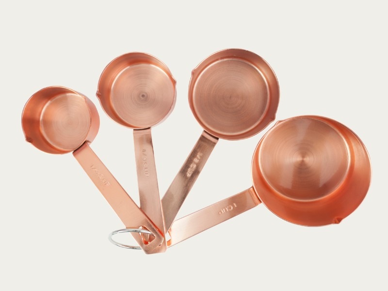 Close-up of copper measuring cups arranged as essential kitchen tools for home cooks