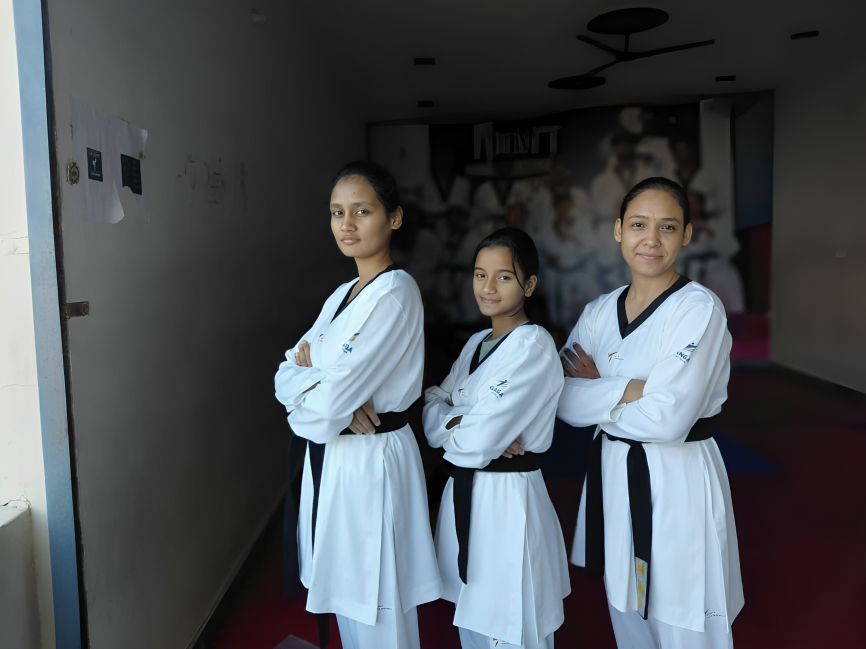 three women in white uniforms standing in a hallway