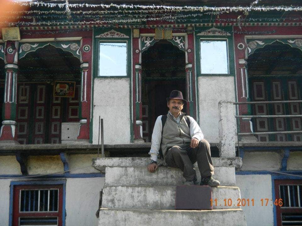 a man sitting on a ledge in front of a building