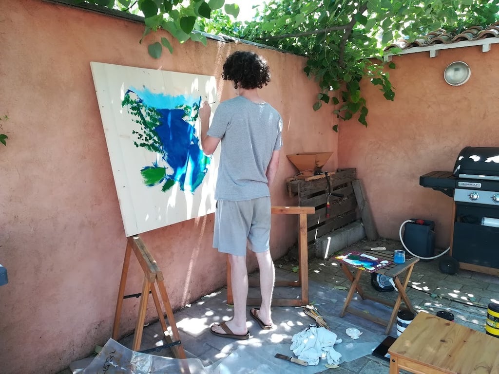 un homme qui peint dans un jardin