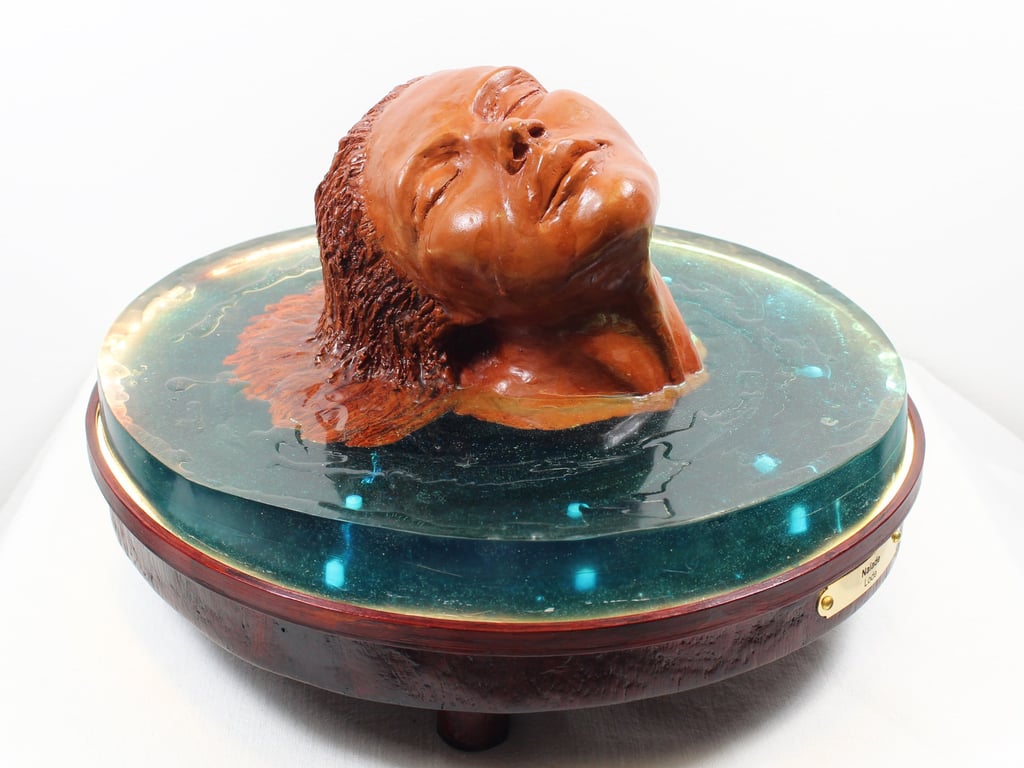 Sculpture de l'artiste Lode intitulée Naïade, représentant le buste d'une femme dans l'eau.  