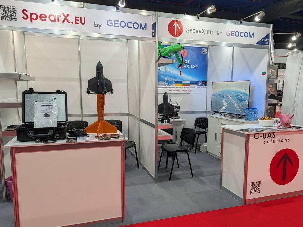SpearX.eu by GEOCOM exhibition booth featuring a rocket booster model and C-UAS drone defense solutions.