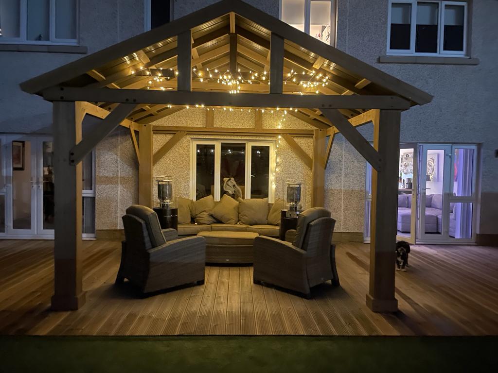 Modern Gazebo with feature lighting, patio heaters and large sofa.