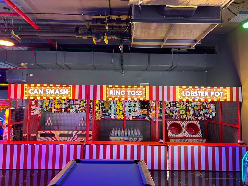 a game room with a pool table and carnival Games