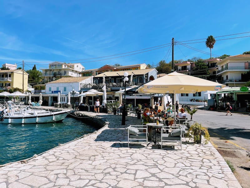 a group of people sitting at tables near a dock
