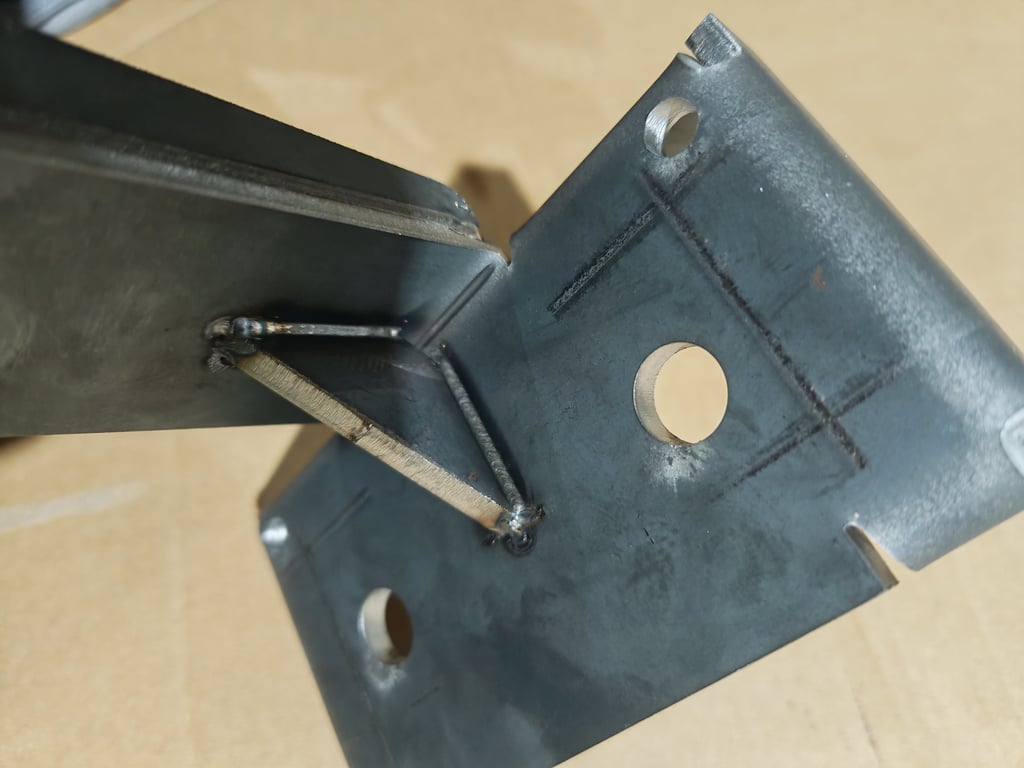 Close-up of a structural steel bracket with a welded gusset plate for metal fabrication reinforcement.
