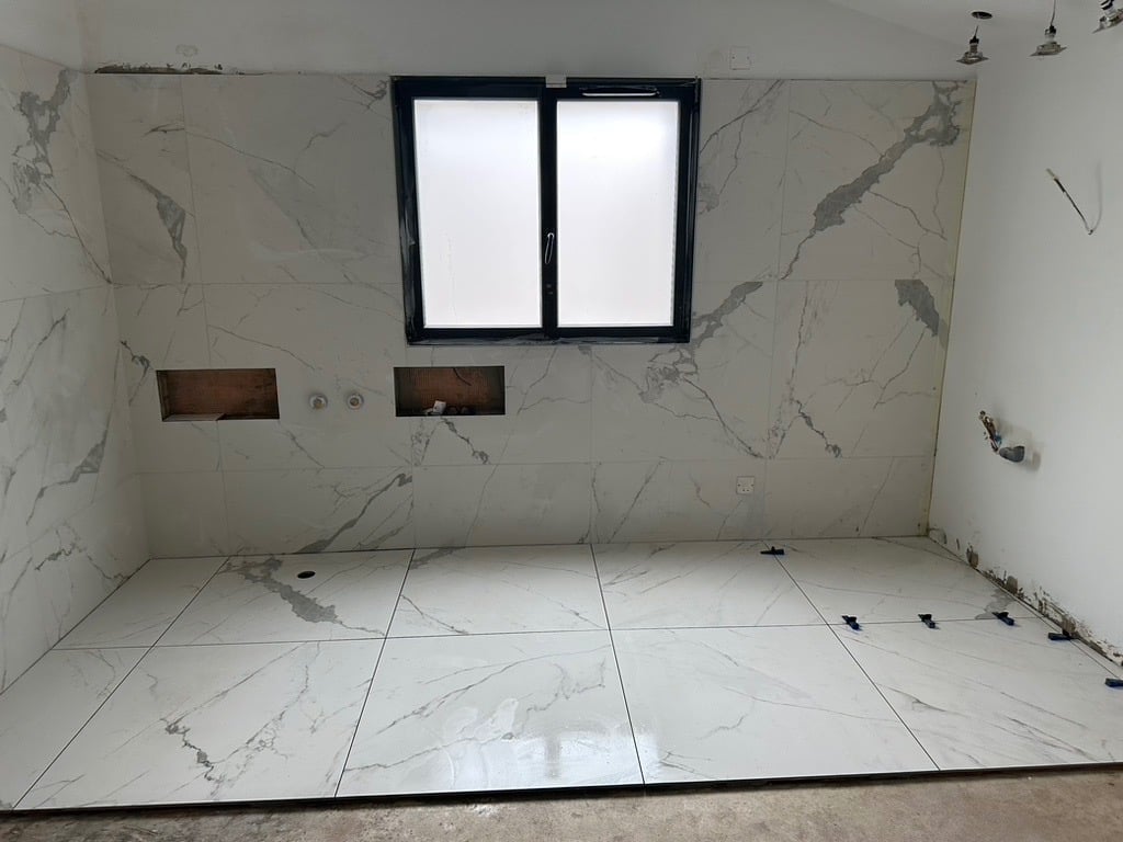 Résultat final après rénovation complète avec pose de carrelage marbre blanc grand format. Harenova