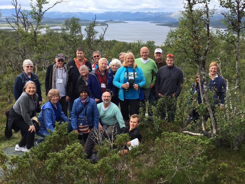 a group of Telelaget members at the top of a hill in norway overlooking a lake
