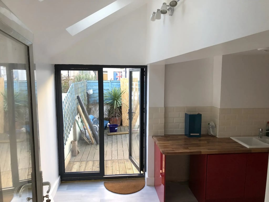 Modern rear house extension with bifold doors opening to garden in Brighton by T.L.E Constructing.