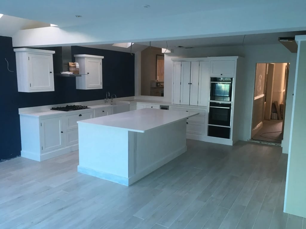 Large open-plan kitchen with island and fitted cabinets in renovated Brighton property.