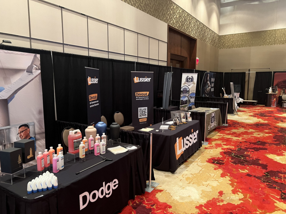 Dodge and Lussier exhibition booths at a professional convention with funeral supplies and banners.