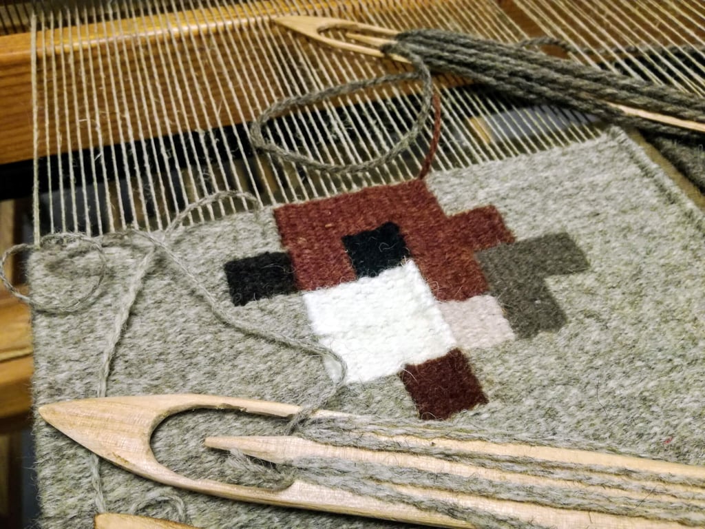 Miniature kilim au motif géométrique pixelart d’un moineau sur un métier à tisser traditionnel