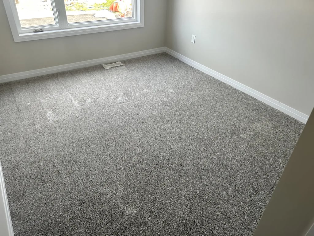 Bedroom with grey plush carpet installed wall-to-wall in Alymer Ontario residential home, soft and cozy flooring