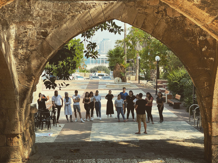 a group of people standing around a stone arch