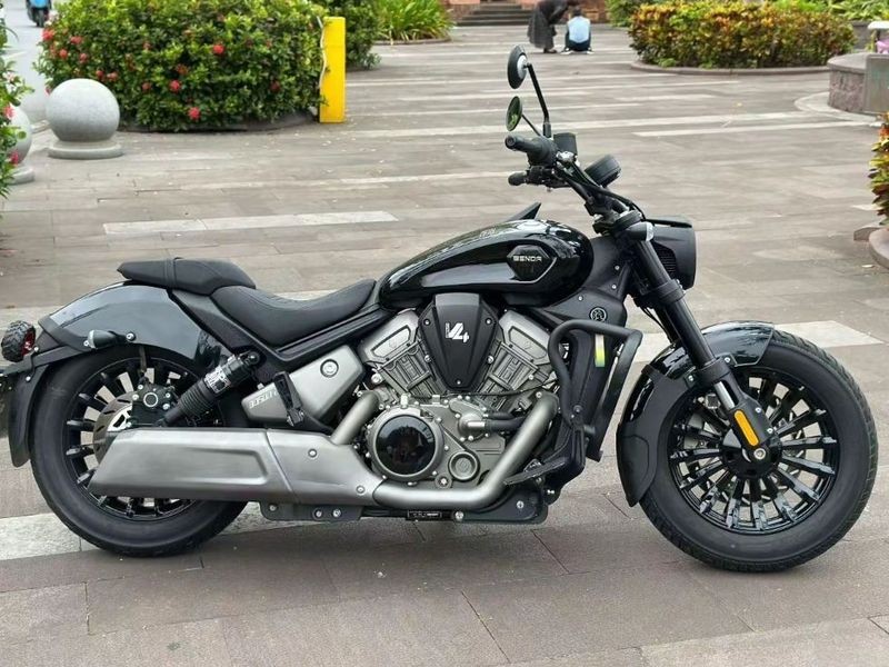 Side view of a black Benda Dark Flag 500 V4 cruiser motorcycle parked on a paved plaza.