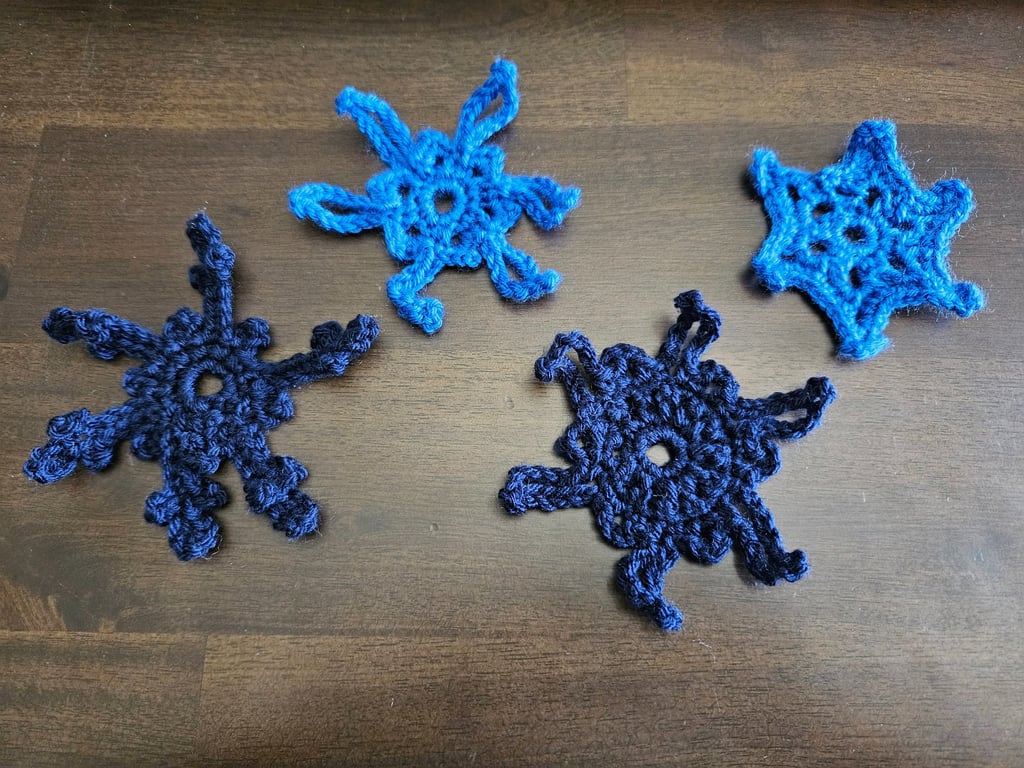 blue crochet snowflakes on a wooden table